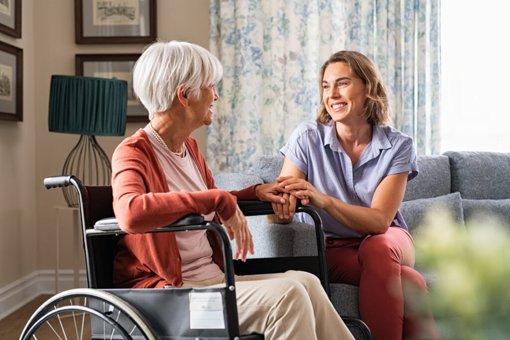 Adult daughter visiting her elderly mother at home to talk through Medicaid planning for aging parents