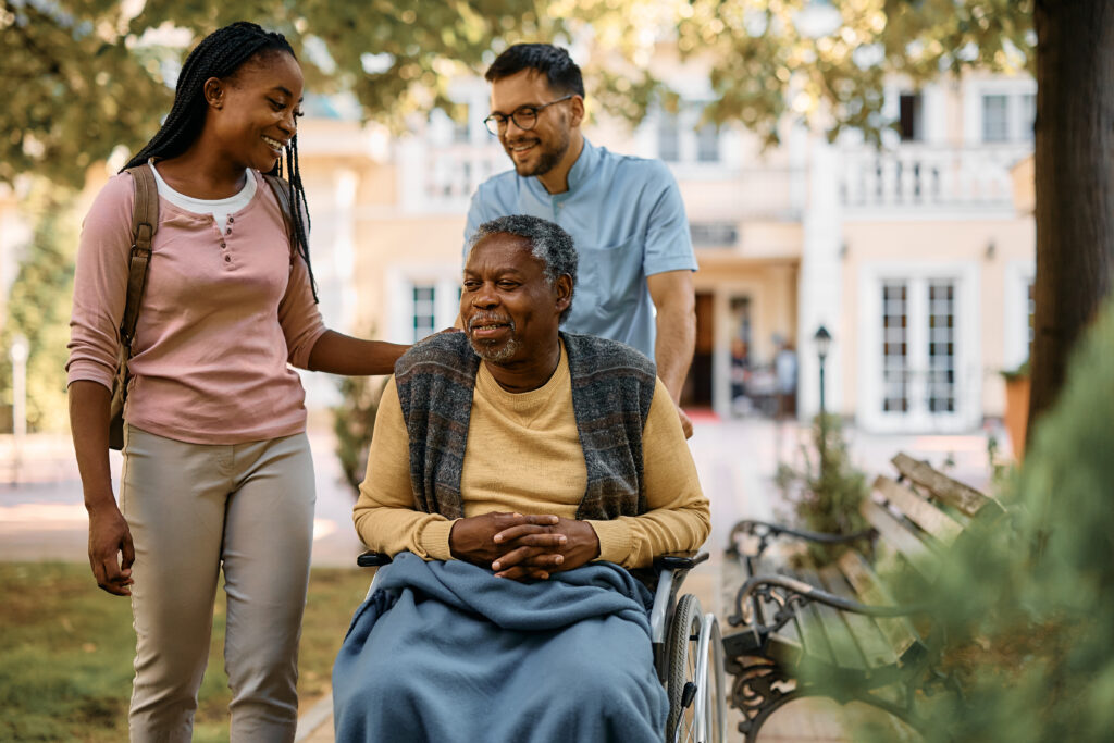 Adult daughter visiting her elderly father in a nursing home